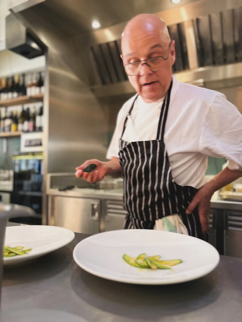 A chef preparing dishes in the open kitchen at The Melusine