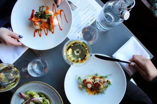 Guests sharing seafood plates and white wine around a table